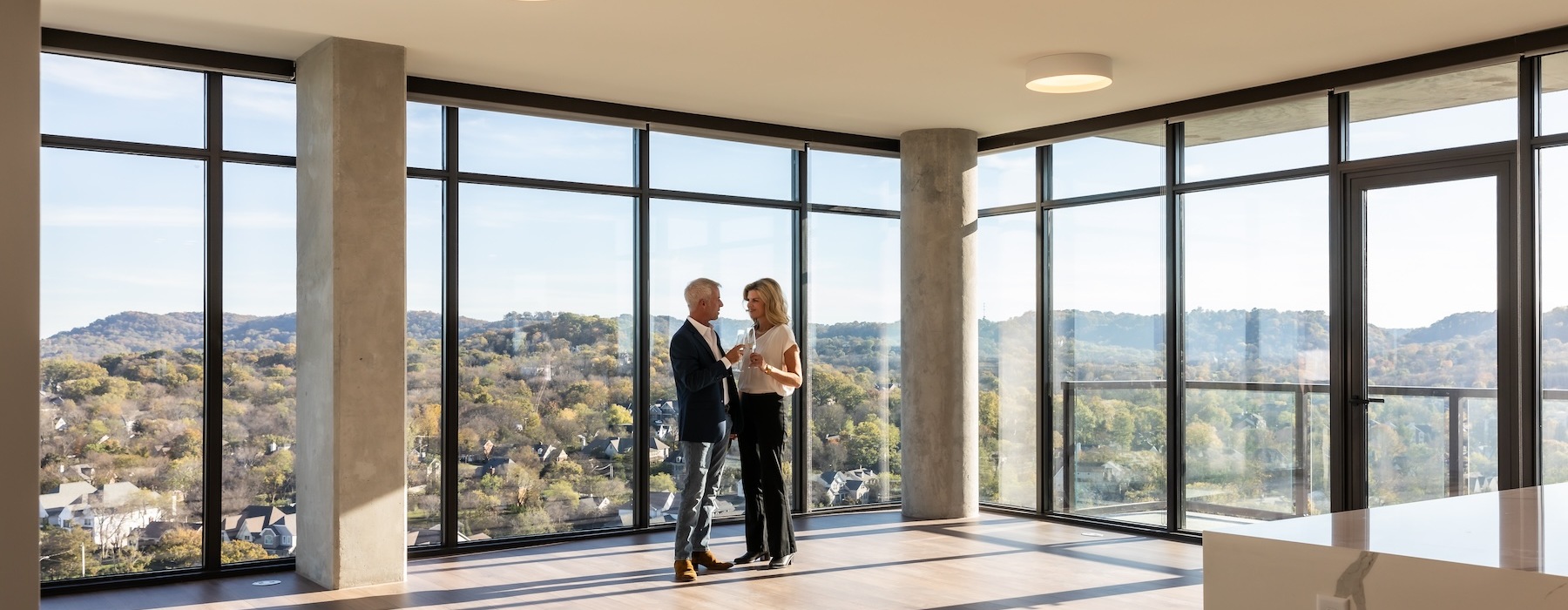 rendering of a penthouse floor with people embracing beside the window