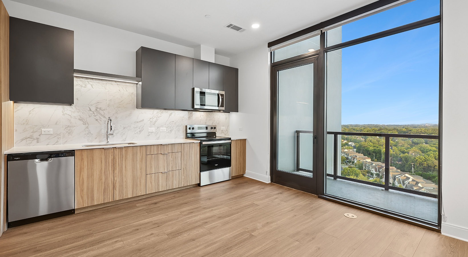 Beautiful kitchens with designer finishes kitchen with wood cabinets by a glass wall and balcony